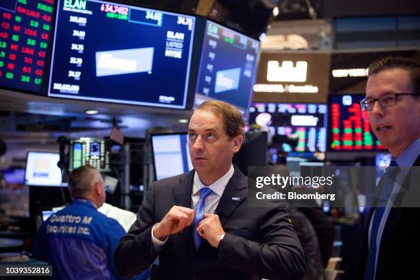 Jeff Simmons, president and chief executive officer of Elanco Animal Health Inc., center, adjusts his tie before an interview on the floor of the New...