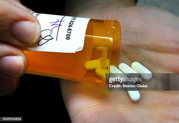 April Mach, a pharmacist at Angell Animal Medical Center, empties a prescription bottle of opioid painkillers that she filled for a patient at the...