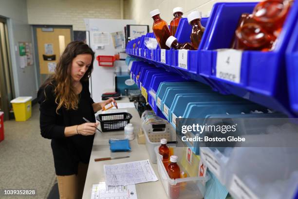 April Mach, a pharmacist at Angell Animal Medical Center fills a prescription of opioid painkillers for a patient at the pharmacy inside the facility...