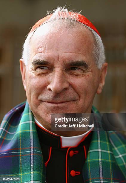 Cardinal Keith Patrick O'Brien unveils the world's first ever Papal visit tartan outside the Scottish Parliament, before handing it over to...