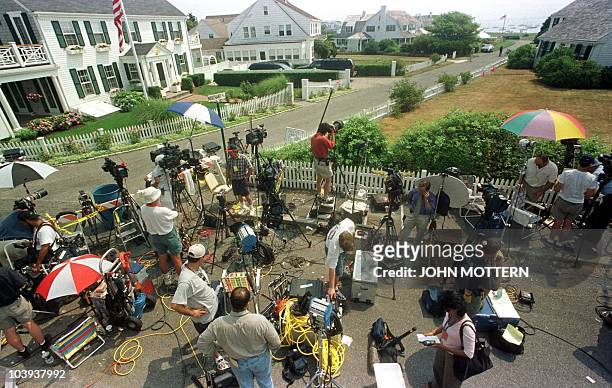 Members of the media stand by the entrance on the road leading to the Kennedy family compound in Hyannisport, Massachusetts 19 July 1999 where family...