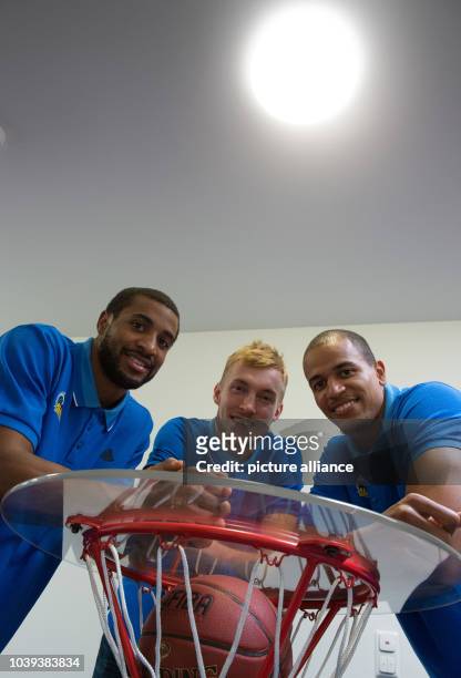 Players from the basketball team lba Berlin Alex King, Niels Giffey and Jordan Taylor smile during a press conference before the coming game in...