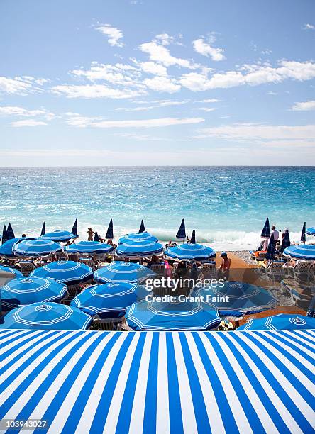 view of mediterranean and beach umbrellas - côte d'azur stock-fotos und bilder