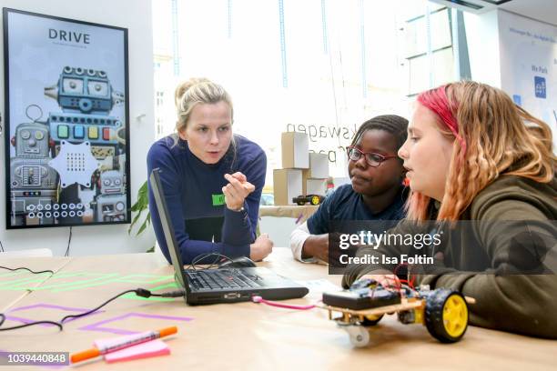 Former German swim olympic gold medalist Britta Steffen with two Arche kids during the kids workshop 'Driven by Kids' hosted by Volkswagen AG at...