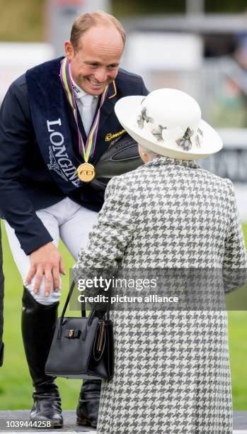 Queen Elizabeth II congratulates winner Michael Jung during the presentation ceremony of the 2015 Horse Eventing European Championships in Blair...