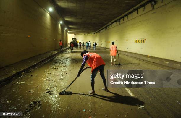 Workers clean the underpass which was closed for daily commuters due to water-logging at Rajiv Chowk on September 24, 2018 in Gurugram, India. The...