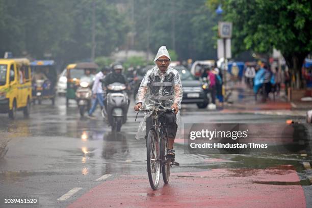 Commuter rides a bicycle during rain at Netaji Subhash Marg on September 24, 2018 in New Delhi, India. The continuous downpour throughout the day...