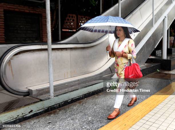 Commuter shelters under an umbrella at ITO following rains on September 24, 2018 in New Delhi, India. The continuous downpour throughout the day...