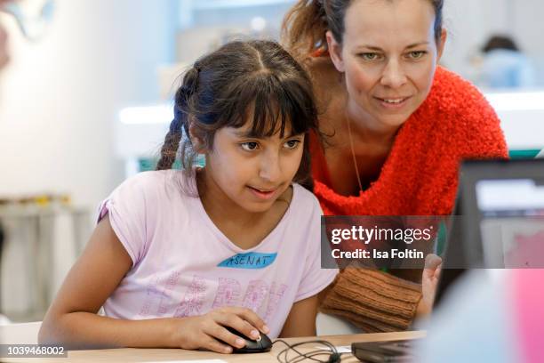 Steffi Hoffrichter and an Arche kid during the kids workshop 'Driven by Kids' hosted by Volkswagen AG at DRIVE Volkswagen Group Forum on September...