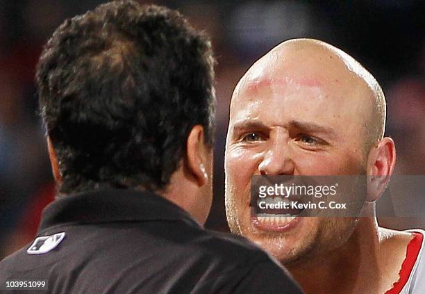 Matt Holliday of the St. Louis Cardinals argues with homeplate umpire Mike DiMuro after getting ejected in the fourth inning against the Atlanta...