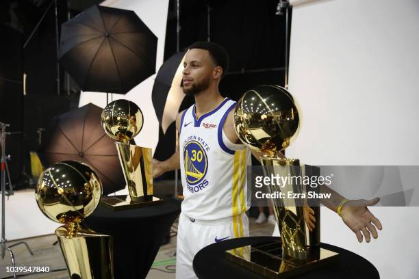 Stephen Curry of the Golden State Warriors poses with three Larry O'Brien NBA Championship Trophies during the Golden State Warriors media day on...