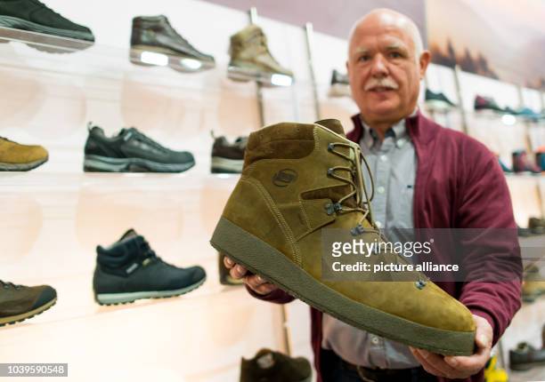 Shoe salesman Georg Wessels holds up a hand-made size 66 shoe at the GDS trade fair in Duesseldorf, Germany, 10 February 2016. For years Wessels'...