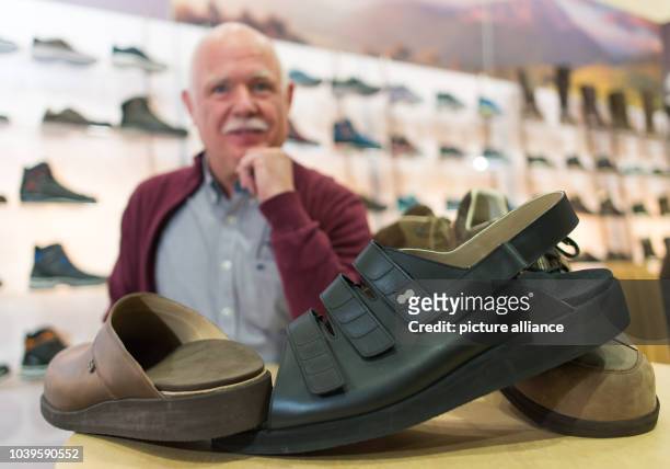 Shoe salesman Georg Wessels holds up hand-made size 66 shoes at the GDS trade fair in Duesseldorf, Germany, 10 February 2016. For years Wessels' shoe...