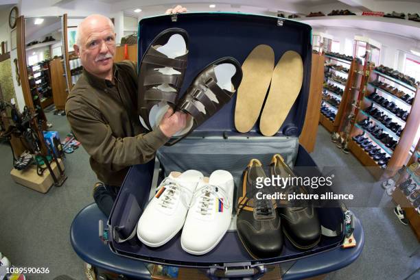 Shoemaker Georg Wessels places oversized men's shoes in a suitcase in his shop in Vreden, Germany, 15 April 2013. Wessels manufactures shoes for...