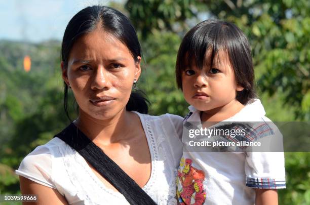 Silvia Shiguango of the indigenous Huaorani tribe stands with her young son Joel near an oil production site in the city that lives off oil, Coca,...