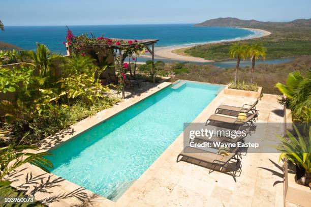 pool, lounge chairs, gazebo overlooking beach - tamarindo stock pictures, royalty-free photos & images