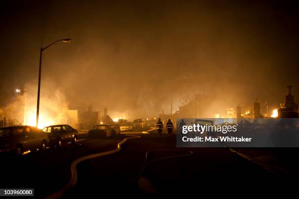 Firefighters walk down the street through the smoke during massive fire in a residential neighborhood September 9, 2010 in a San Bruno, California. A...