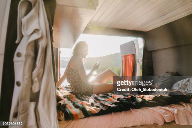 Woman with smartphone  in campervan near Lake of Sainte-Croix