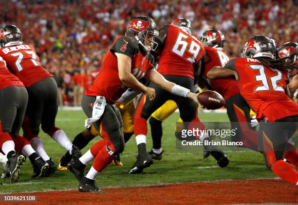 Quarterback Ryan Fitzpatrick of the Tampa Bay Buccaneers hands off to running back Jacquizz Rodgers during the second quarter of a game against the...