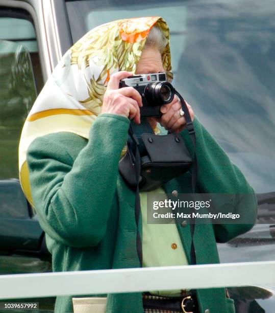 Queen Elizabeth II seen taking photographs of Prince Philip, Duke of Edinburgh as he competes in the Driven Dressage element of the Carriage Driving...