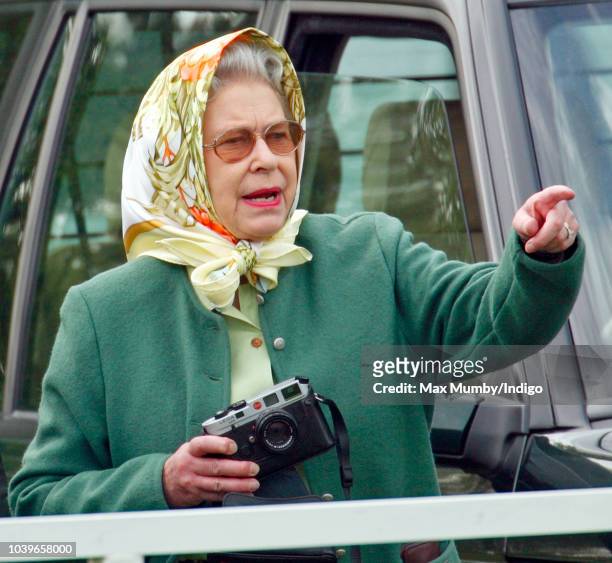 Queen Elizabeth II seen holding her Leica camera as she watches Prince Philip, Duke of Edinburgh compete in the Driven Dressage element of the...