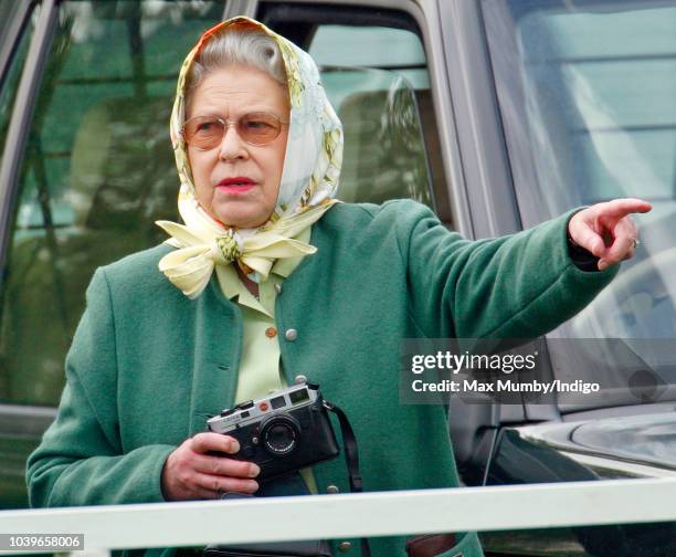 Queen Elizabeth II seen holding her Leica camera as she watches Prince Philip, Duke of Edinburgh compete in the Driven Dressage element of the...