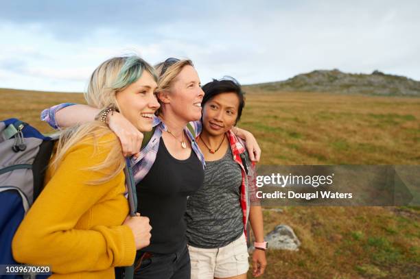 happy and positive hiking friends huddle together on a rocky moorland. - tres amigos fotografías e imágenes de stock