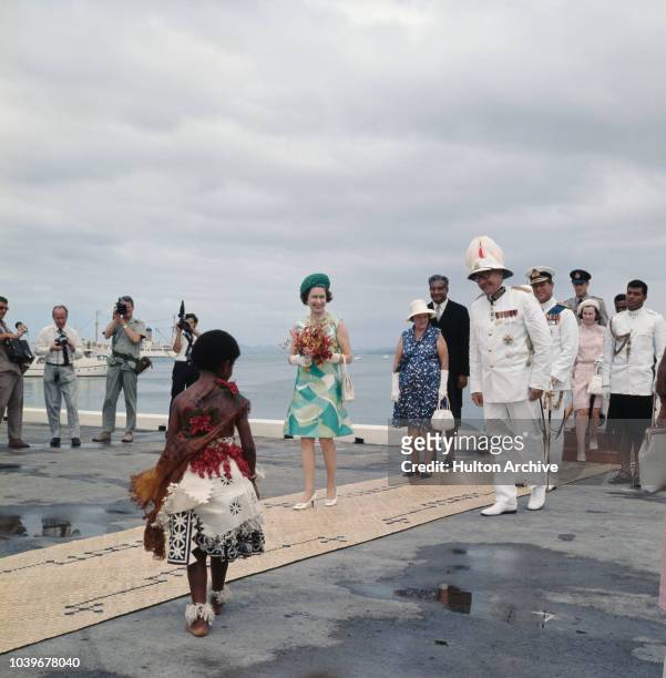Queen Elizabeth II is greeted by a young girl on her arrival at Suva in Fiji, during a tour to mark the bi-centenary of Captain James Cook’s maiden...