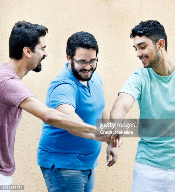 junge freunde berühren hände machen einen bund - musketier stock-fotos und bilder