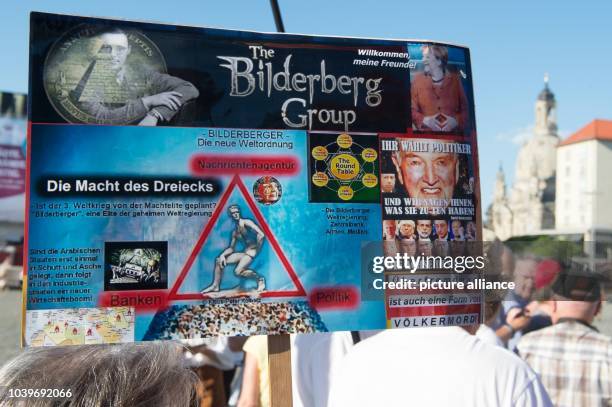 Supporters of the anti-Islamic Pegida movement hold a sign with the words 'The Bilderberg Group' during a rally on the Altmarkt in Dresden, Germany....