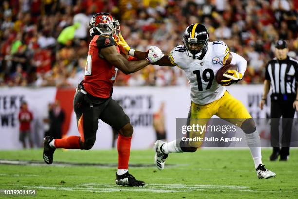 JuJu Smith-Schuster of the Pittsburgh Steelers stiff-arms M.J. Stewart of the Tampa Bay Buccaneers on September 24, 2018 at Raymond James Stadium in...