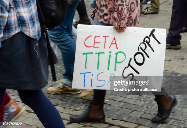 Sympathizers of the groups attac, Verdi, BUND, Oekoloewen, and the network 'Vorsicht Freihandel' demonstrate holding a sign reading 'Stoppt CETA,...