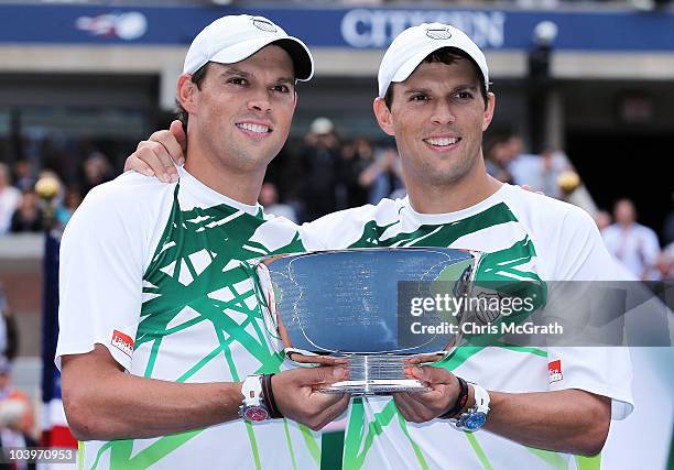 Bob Bryan of the United States and Mike Bryan of the United States hold the championship trophy after defeating Rohan Bopanna of India and...