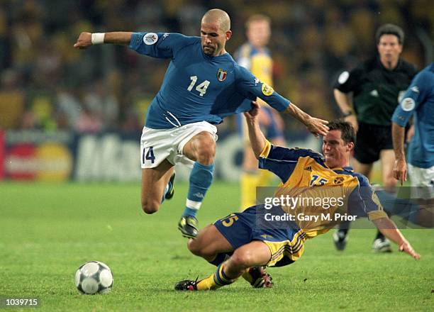 Luigi Di Biagio of Italy hurdles Daniel Andersson of Sweden during the European Championships 2000 group match at the Philips Stadium in Eindhoven,...