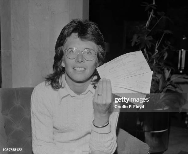 American professional tennis player Billie Jean King pictured holding three cheques, sent to her by the All England Lawn Tennis and Croquet Club, in...