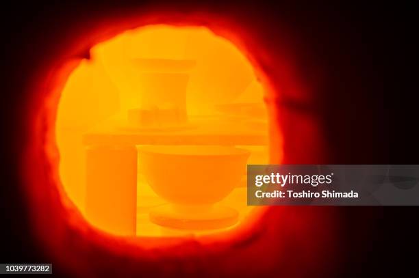 process of burning potteries from kiln's window - ceramics fotografías e imágenes de stock