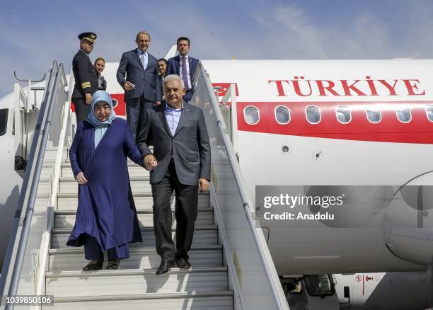 Turkish Parliament Speaker Binali Yildirim and his wife Semiha Yildirim get off the plane as they arrive at Samarkand International Airport during...