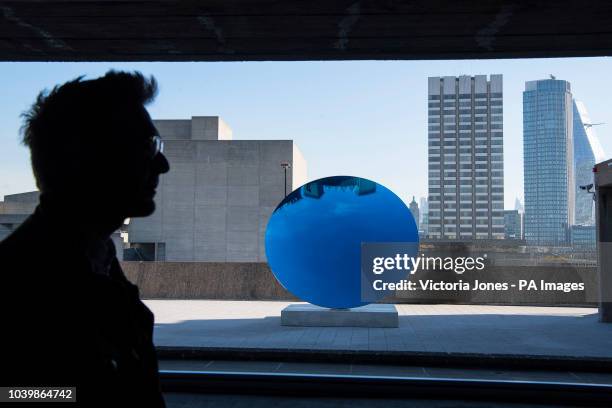 Man views 'Sky Mirror, Blue, 2016' by Anish Kapoor, during a press preview for the exhibition: Space Shifters at the Hayward Gallery, Southbank...