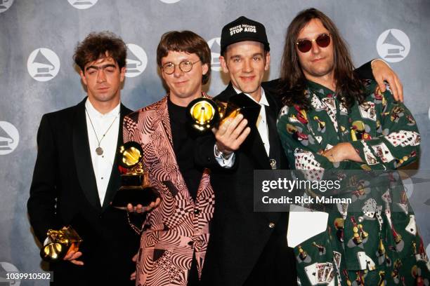 Members of the band R.E.M., lead singer Michael Stipe, guitarist Peter Buck, bass guitarist Mike Mills, and drummer Bill Berry, accept the award for...