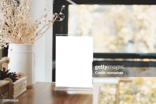 menu card holder with white sheet of paper on table in cafe.card display promotion and information for customer,picture stand,sign holder and photo frame template. - white paper template stock-fotos und bilder