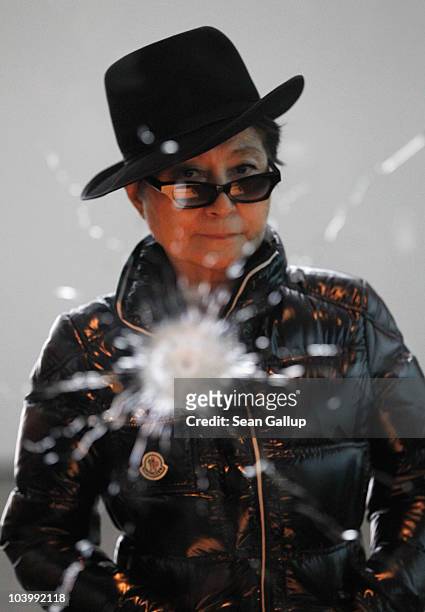 Artist Yoko Ono stands in front of her piece "A Hole" ahead of the opening of her art installation "Das Gift" at the Haunch of Venison gallery on...
