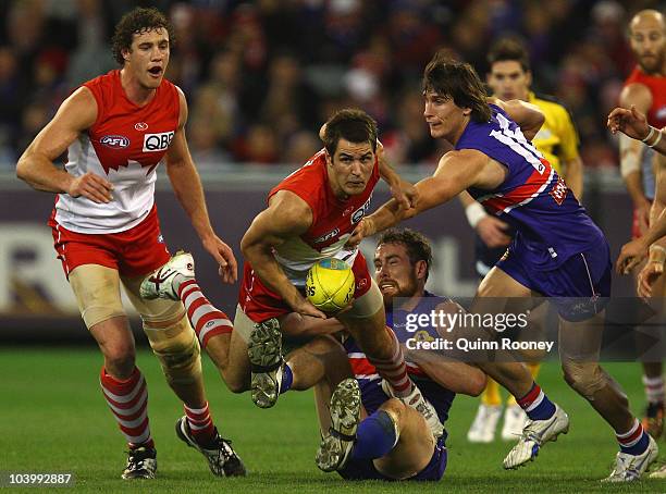 Josh Kennedy of the Swans handballs out of a pack whilst being tackled by Ben Hudson of the Bulldogs during the AFL First Semi Final match between...