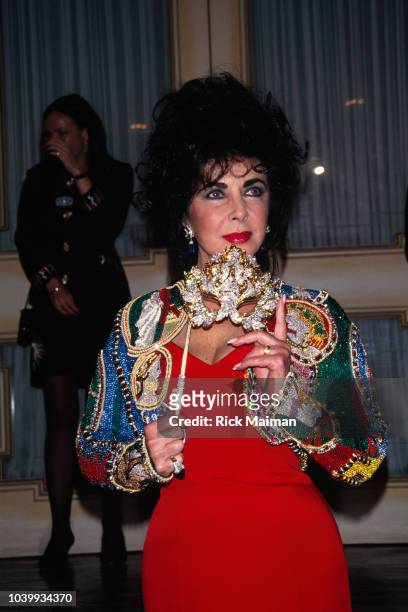 Elizabeth Taylor presents the Lachrymosa diamond and gold mask designed by Henry Dunay at an auction at Christies on behalf of the American...