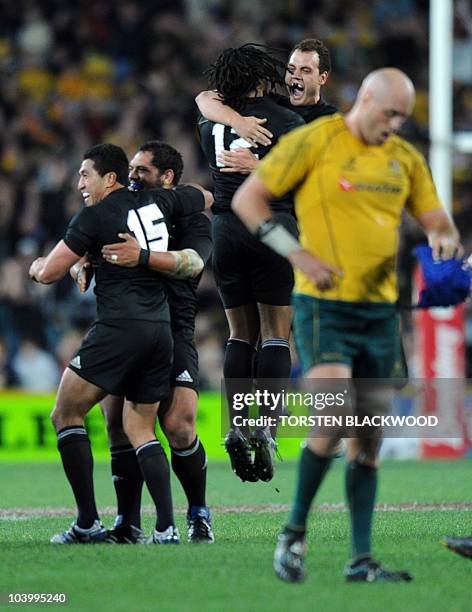 New Zealand celebrate their win as Australian lock Nathan Sharpe laments after the final whistle of the Tri-Nations between Australia and New Zealand...