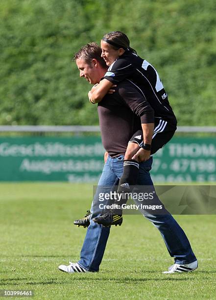Coach Sven Kahlert of Frankfurt carries one of his players, Sandra Smisek, after the Women's Bundesliga match between FCR Duisburg and FFC Frankfurt...