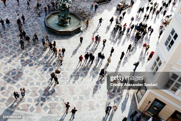 high angle view of crowd of people on the city square during sunset - menschenmenge von oben stock-fotos und bilder