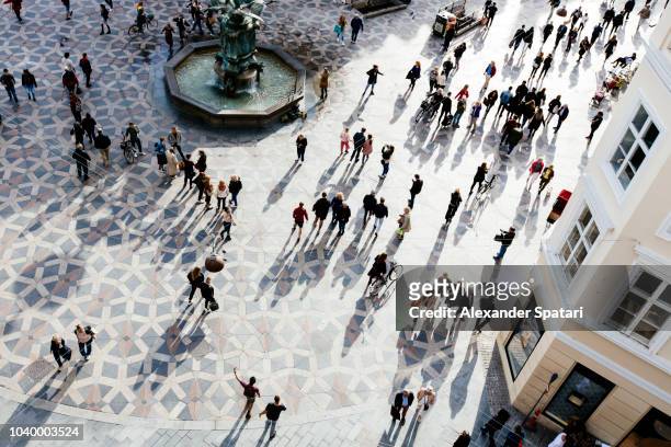high angle view of crowd of people on the city square during sunset - crowd of people from above stock pictures, royalty-free photos & images