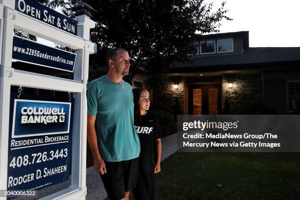 Homeowner Sean Cook, left, and his daughter Emma stand next to the for sale sign outside their home in San Jose, Calif., on Wednesday, Sept. 12,...