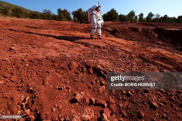 French M6 TV channel presenter, Eglantine Emeyé, wearing a Gandolfi 2 space suit, from Comex space division, walks for a TV program on September 25,...