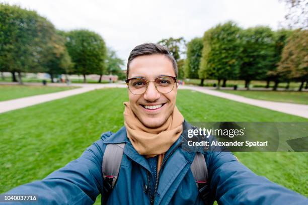 selfie of a young man in eyeglasses in a park - selandia fotografías e imágenes de stock